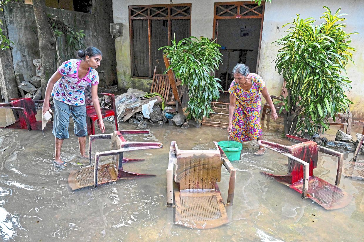 All that’s left: Residents salvaging their belongings at an inundated house following flash floods in the aftermath of Cyclone Ditwah, in Wellampitiya on the outskirts of Colombo. — AFP