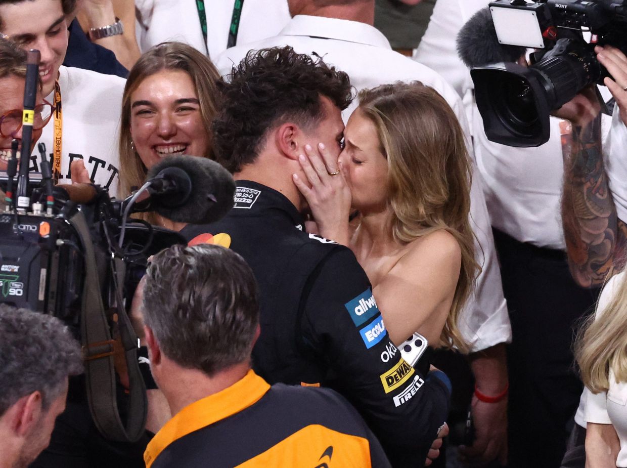 McLaren's Lando Norris celebrates with his girlfriend Magui Corceiro after becoming the 2025 Formula One World Champion. Formula One F1 - Abu Dhabi Grand Prix - Yas Marina Circuit, Abu Dhabi, United Arab Emirates - Sunday, December 7, 2025 -- Photo: REUTERS/Amr Alfiky