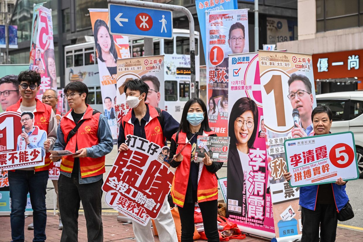 Supporters campaign for their candidates in the Legislative Council elections in the Wanchai district of Hong Kong on Sunday, December 7, 2025. -- Photo by Peter PARKS / AFP)