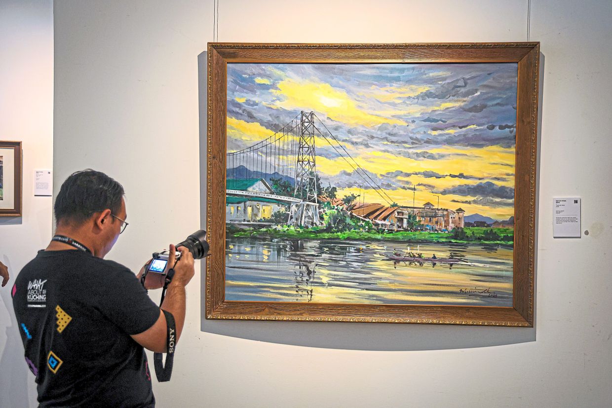 A visitor taking a closer look at one of the paintings in the Memories of Home exhibition.