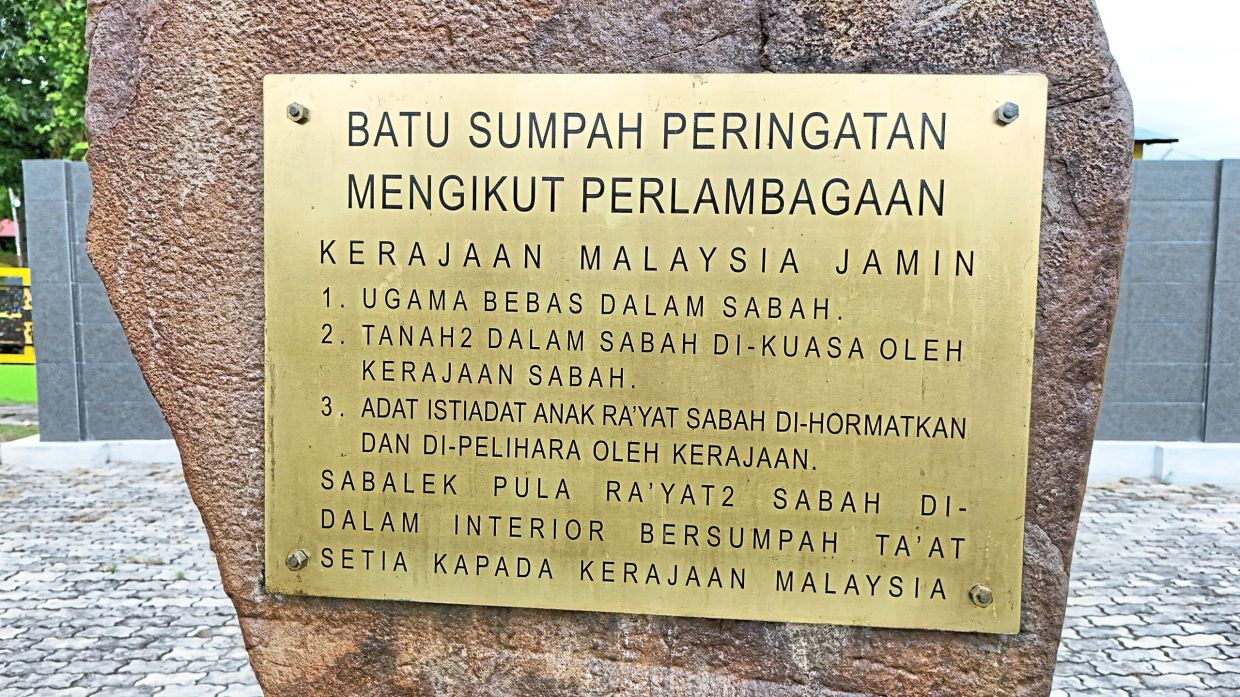 A close-up of the brass plaque listing the three guarantees sought by interior communities in 1963.
