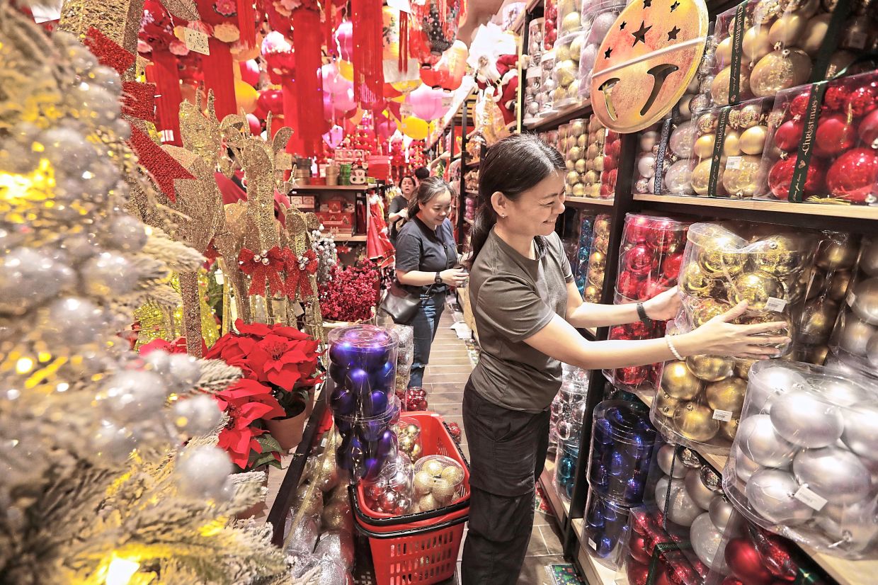Shoppers buying decorations in Jalan Petaling, Kuala Lumpur. — ZULAZHAR SHEbLEE, GLENN GUAN and YAP CHEE HONG/The star