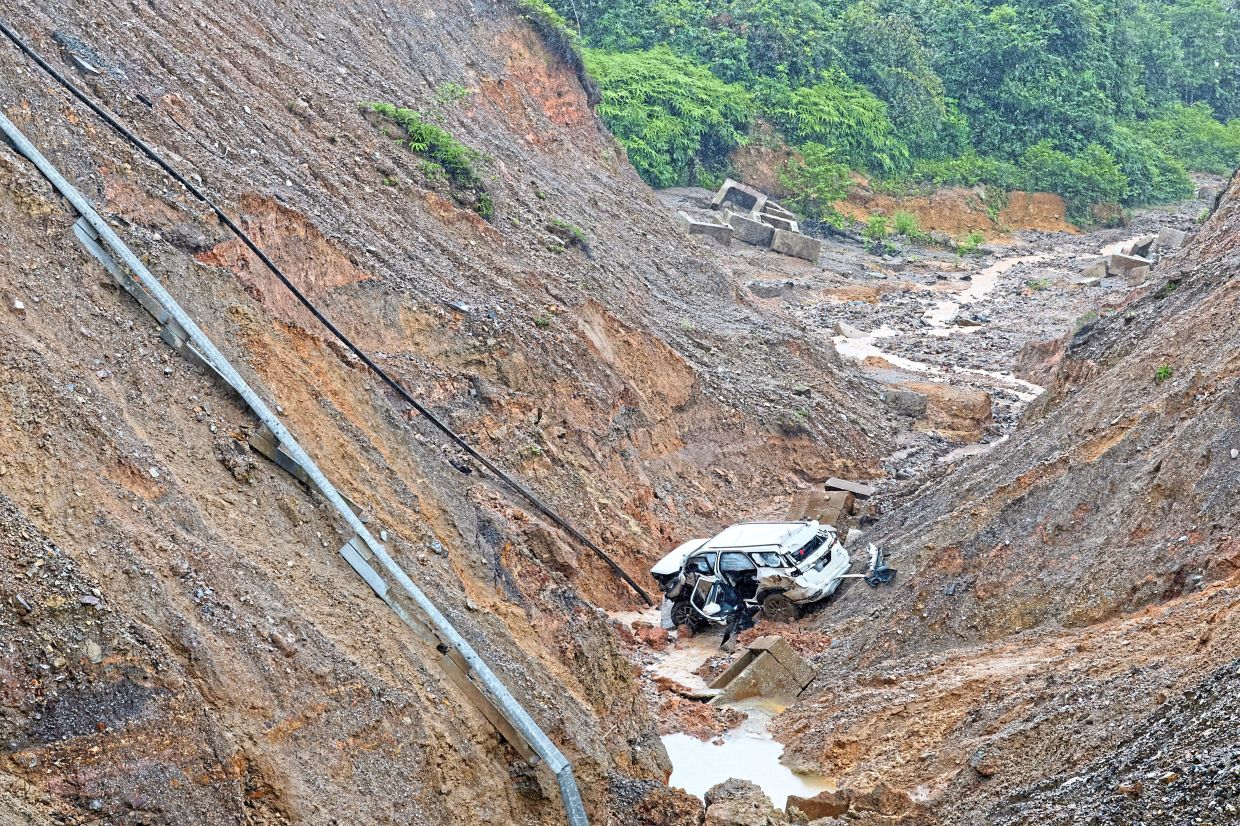 Deadly mistake: Irresponsible parties had moved the barriers and warning signs installed at the landslide site, said Supt Sharudin after a couple’s SUV entered a closed road and plunged into a ravine. — Filepic