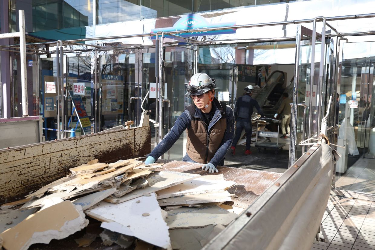 A worker clearIing debris at a shopping centre damaged by the earthquake in Hachinohe City, Aomori Prefecture on Dec 9, 2025. - AFP