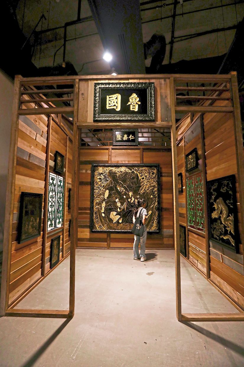 A general view of Gan's 'Invasion And Resistance' (lacquer carving on MDF board, wooden house structure, 2025) installation at the exhibition. Photo: The Star/Low Lay Phon 