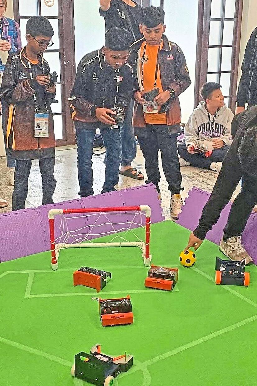 Gears and goals: Malaysian students with their robots in action during WRG 2025 in Taiwan.
