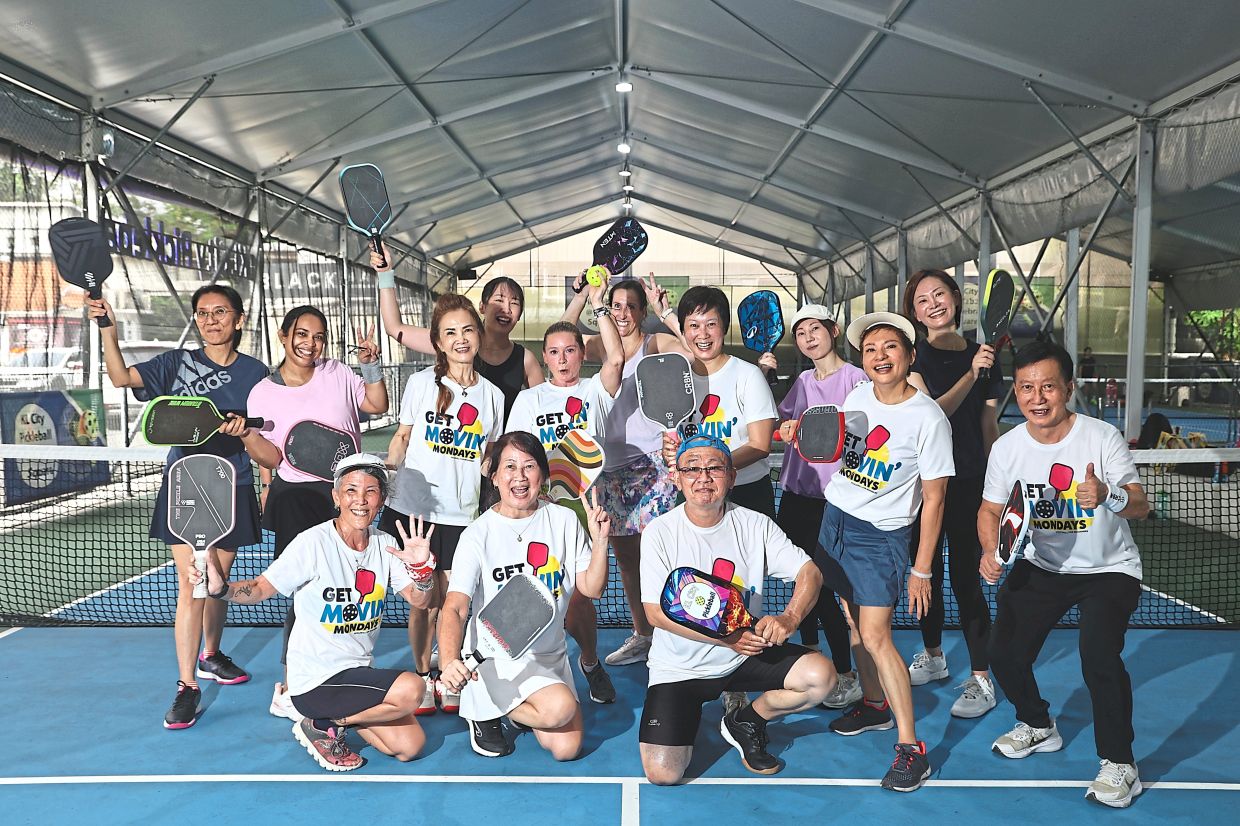 Lum (standing, fifth from right) with other pickleball friends during their Monday session.