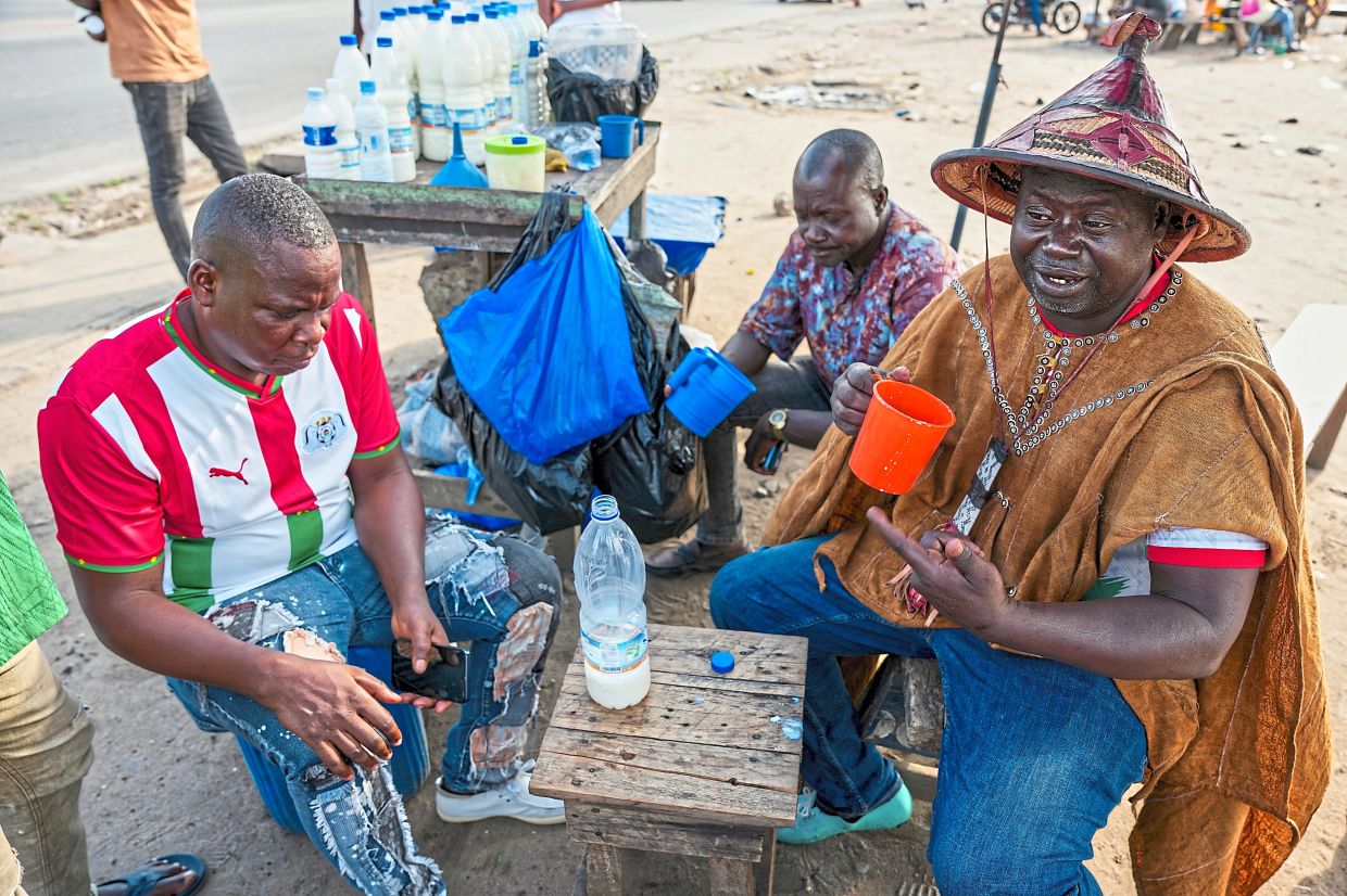 Sonde (right), seen here with his friends at the market, said that 'there is no Fulani without his cattle, that is his identity'.