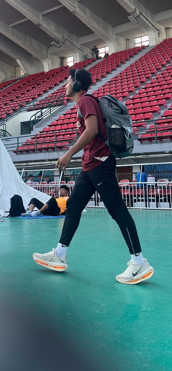 Calm before the storm: Thai star Puripol Boonson walking past Danish Iftikhar Mohd Roslee while he was doing his stretching at the Supachalasai Stadium.