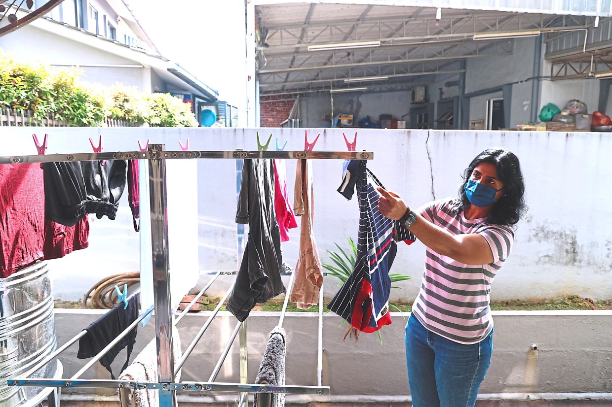 Uma Devi claims that besides aggravating her respiratory issues, soot from the open burning next door often coats her freshly washed clothes. — Photos: ART CHEN/The Star