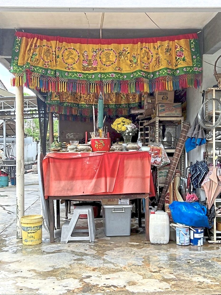 Prayer tables and offerings set up in the porch of the property in Taman Yarl.