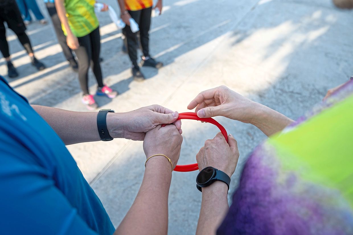 With both holding on to towels or elastic bands, the guide runners accompany the VIPs around the running routes, helping keep them on course.