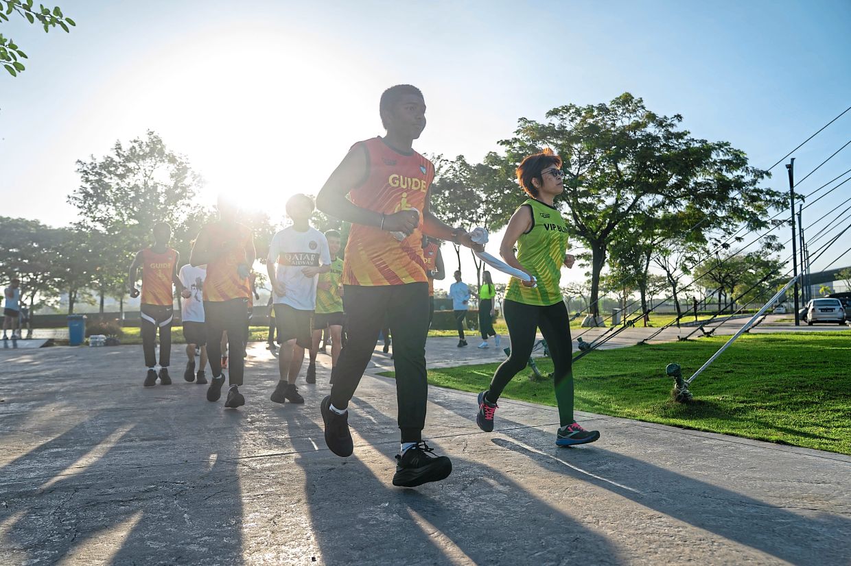 A visually impaired person and guide runner going through the paces during the pre-marathon training session.