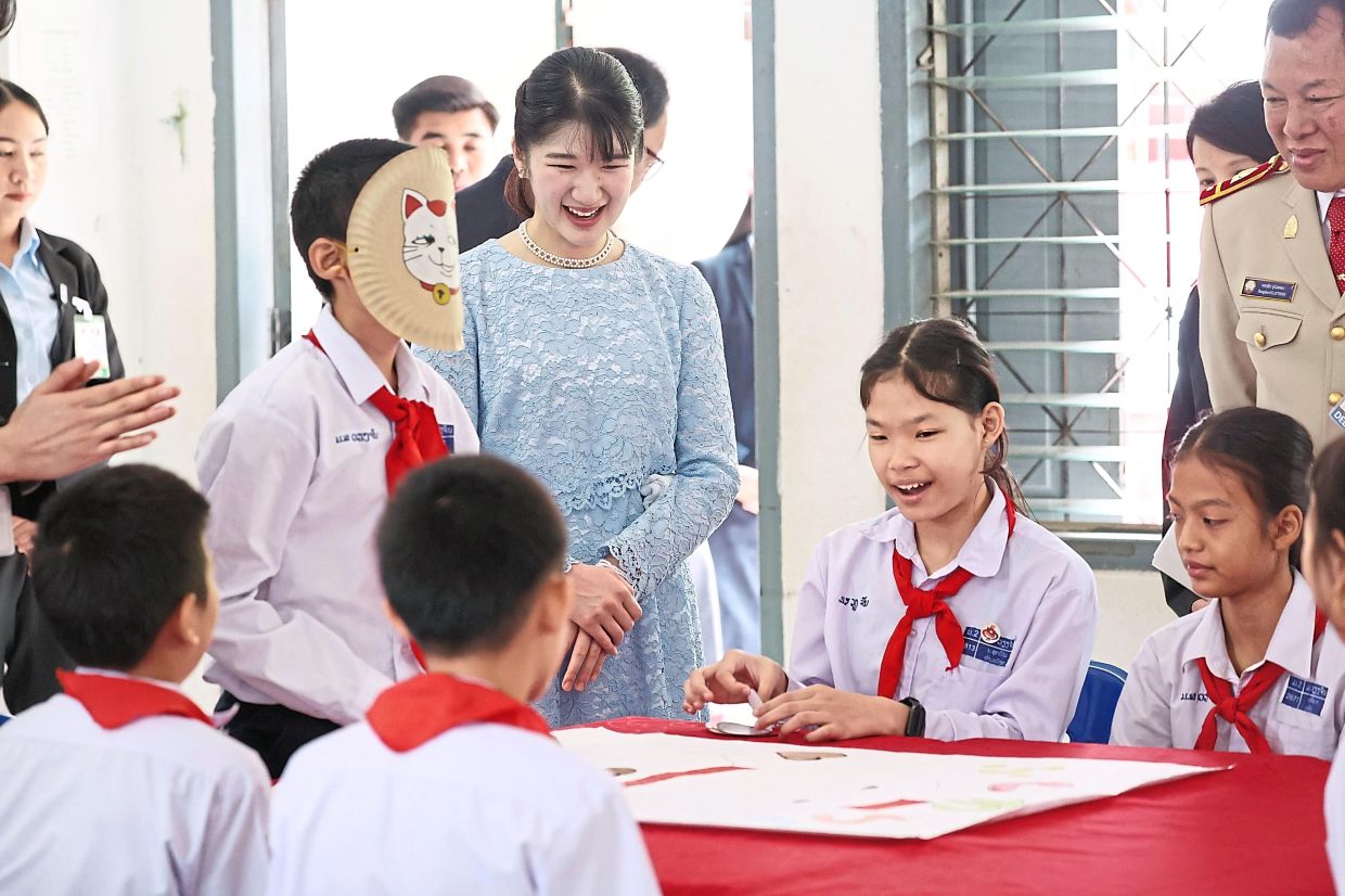 Princess Aiko, the daughter of Japan's Emperor Naruhito and Empress Masako, center, observes a lesson on Japanese culture at a school in Vientiane, Laos, Wednesday, Nov. 19, 2025. (Japan Pool/Kyodo News via AP)