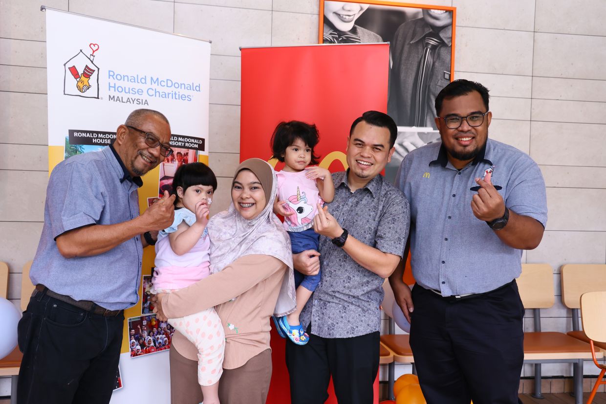 Mohd Nasri (first from left) and Yusof (first from right) with Azimah Rosli (third from left) and her daughter Naurah and her family at the Ronald McDonald Sensory Room at McDonald’s Tampin.