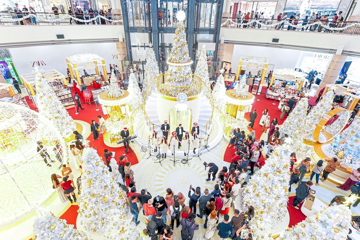 Visitors listening to a choir performing at the centre court in Suria KLCC.