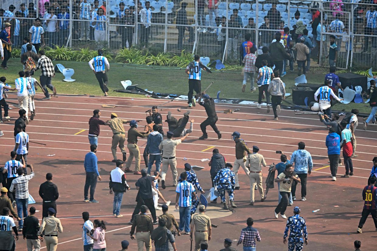 Security personnel try to control the crowd as Inter Miami's Argentine forward Lionel Messi departs from the Salt Lake Stadium in Kolkata on Saturday, December 13, 2025. Thousands of fans packed into a stadium in eastern India on December 13 to cheer on Lionel Messi as the football legend unveiled a 21-metre (70-foot) statue of himself. - Photo by Dibyangshu SARKAR / AFP