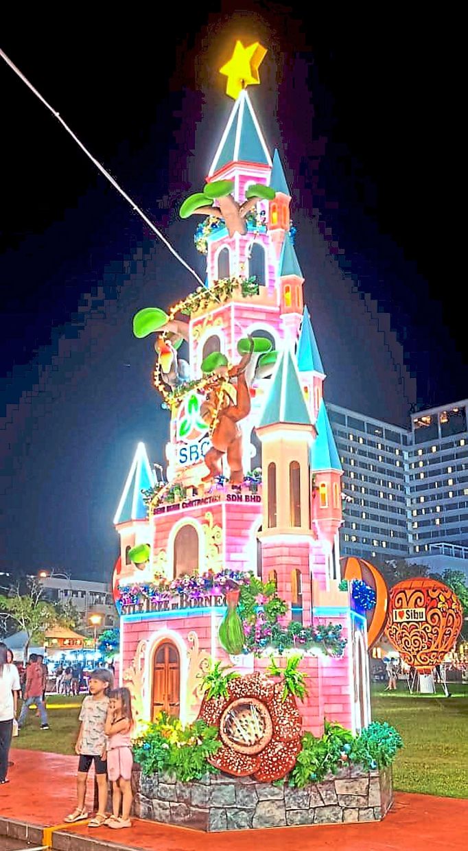 Holiday magic: Two children having their photograph taken in front of one of the many Christmas decorations.