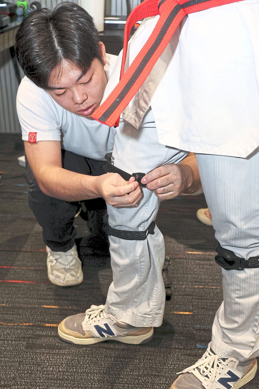 Technical operator Lee Chong Heng strapping one of the nodes on Asadullah’s leg.