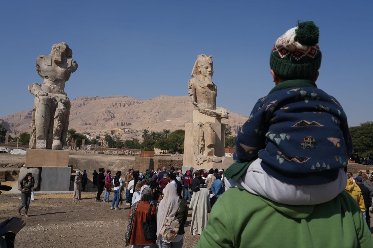 Visitors admire the two giant reassembled alabaster statues of Pharoah Amenhotep III in the southern city of Luxor, Egypt. Photo: AP
