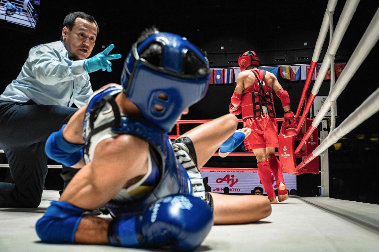 Vietnam boxer Dang Huynh Hai is floored in the tie against Thailand's Chalongchai Minindi in the quarter-finals of the men's 51kg Muay Thai event of the 33rd SEA Games at Lumpinee Boxing Stadium in Bangkok on Sunday, December 14, 2025. -- Photo by Chanakarn LAOSARAKHAM / AFP