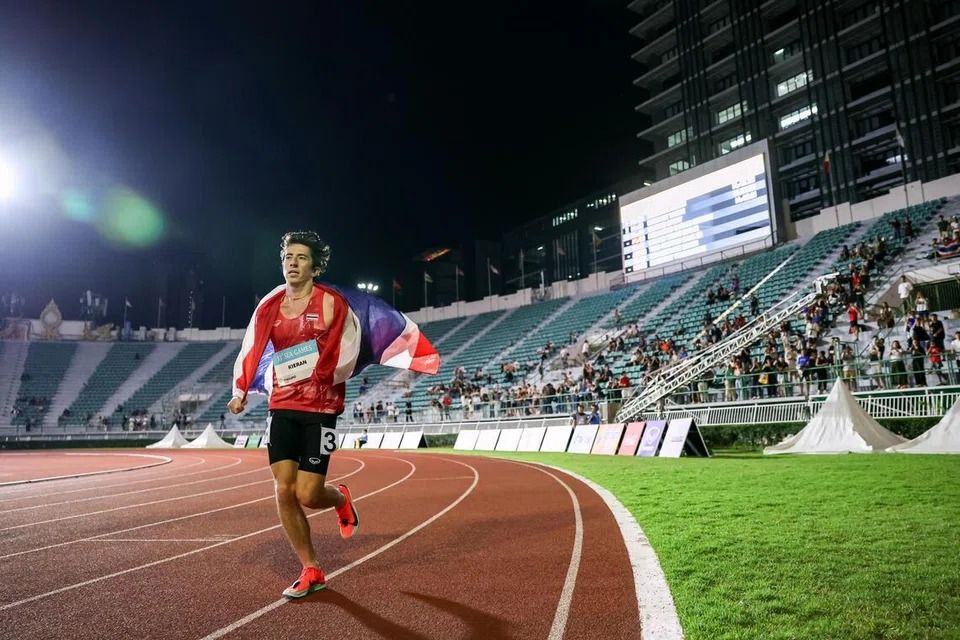 Not many fans were in the Suphachalasai National Stadium as Thai runner Kieran Tuntivate did his victory lap after winning the men's 5,000m finals at the SEA Games in Bangkok on Dec 13. -- ST PHOTO: BRIAN TEO