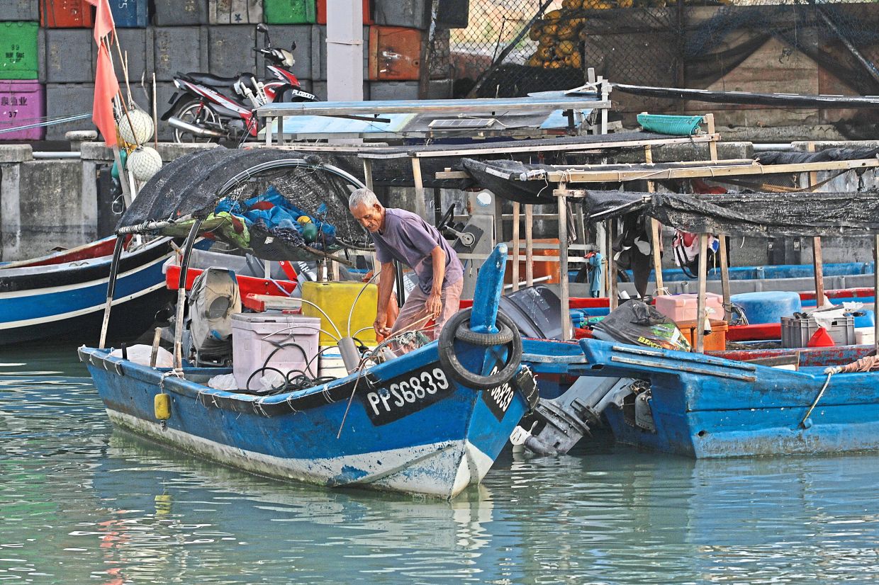 A fisherman preparing his boat at Penang’s Batu Maung jetty before going out to sea. — Photos: LIM BENG TATT/The Star