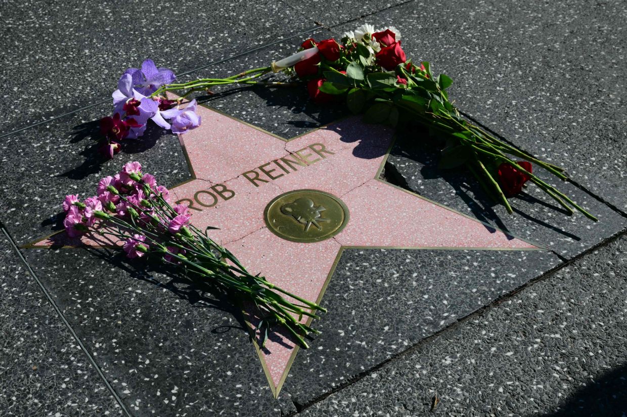 Flowers are left at US actor and director Rob Reiner's Star on the Hollywood Walk of Fame in Los Angeles, California, on December 15, 2025. Reiner's son was charged with murder, police said on December 15, after his father and mother were found dead the previous day in their Los Angeles home. (Photo by Frederic J. Brown / AFP)