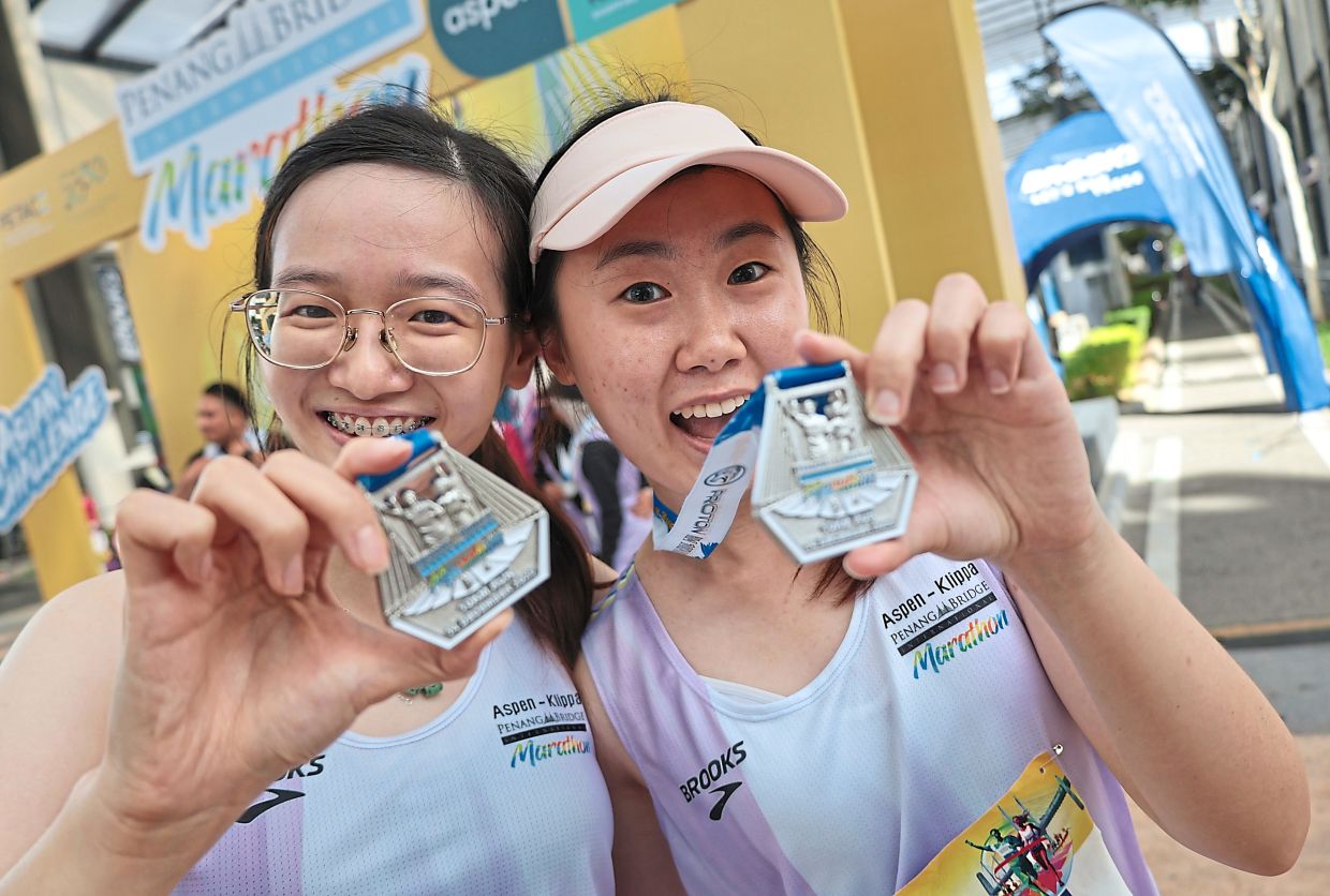 Lian (left) and Lau with their 10km finisher medals.