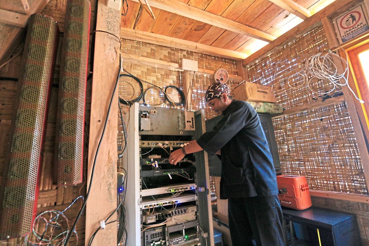 Kang Mulyadi, the community Internet technician, checking the internet equipment. (Photo courtesy of Common Room Network Foundation)