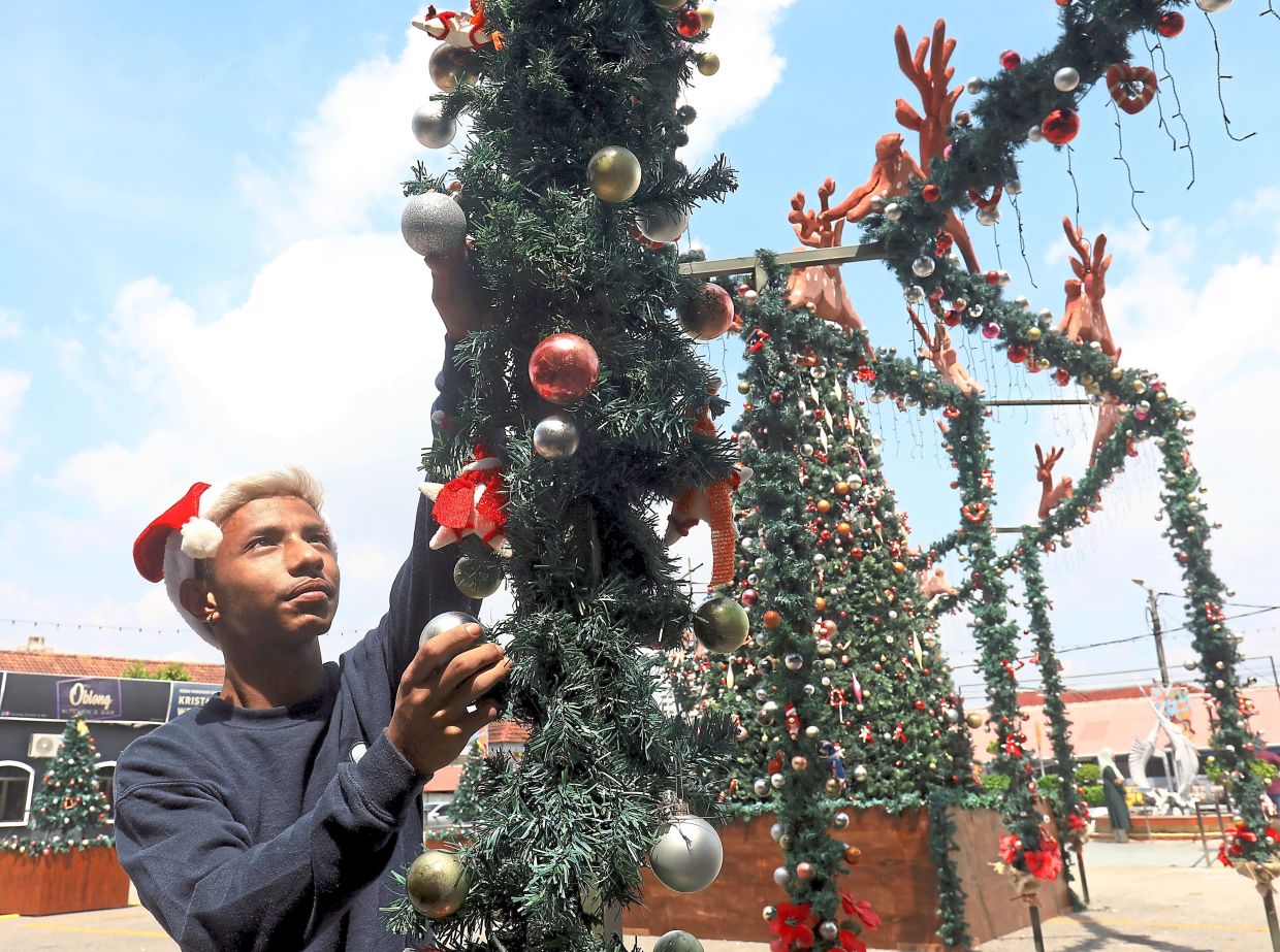 Despite the harsh sun, Lucas does his bit to decorate the Settlement for Christmas. 