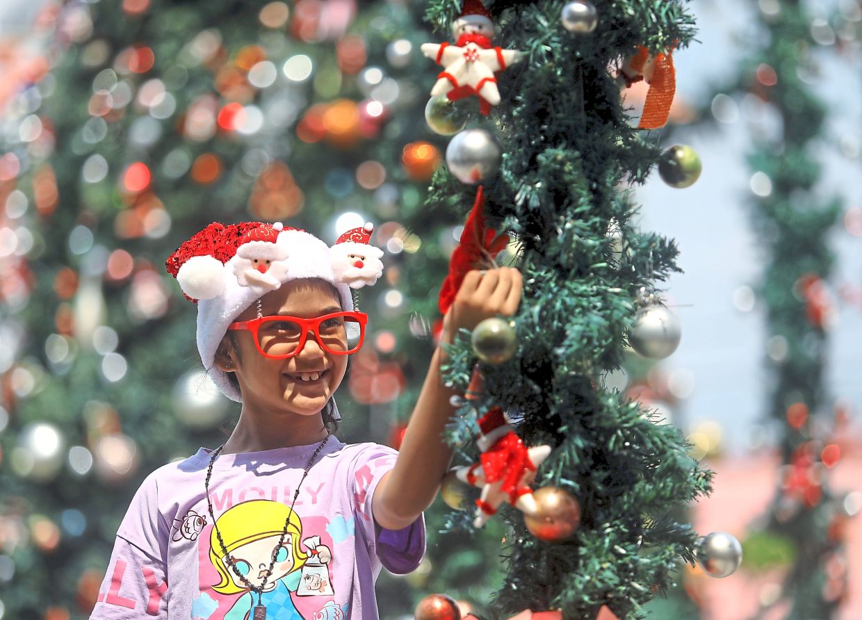 Six-year-old Scarlett Lily Lowe marvels at the Christmas decorations in the Settlement Square.