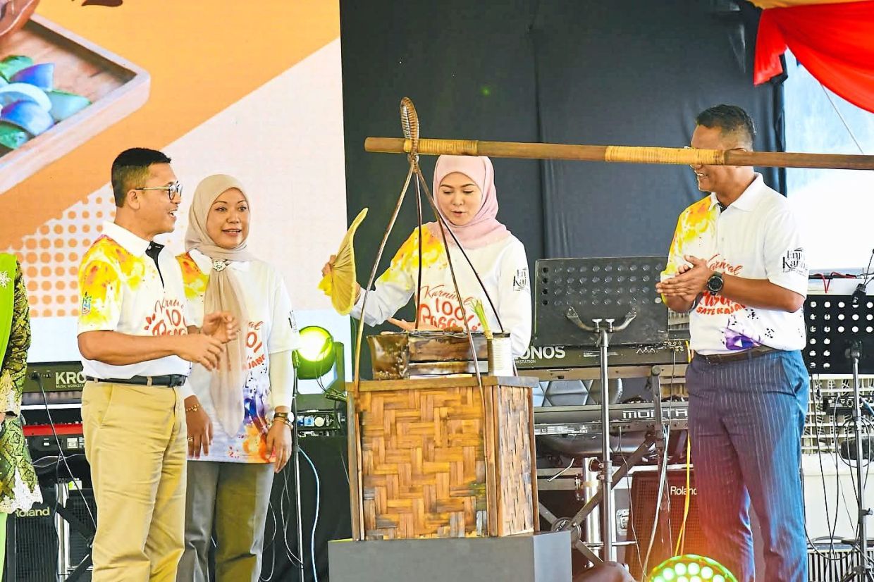 Tengku Permaisuri Norashikin (second from right) fanning a mock charcoal grill at the ceremony to declare Sate Kajang as Selangor heritage food at Stadium Kajang in July 2025. Looking on are (from left) Borhan, Padat chief executive officer Rozzana Rahmat and Kajang Municipal Council president Nazli Md Taib. — Filepic