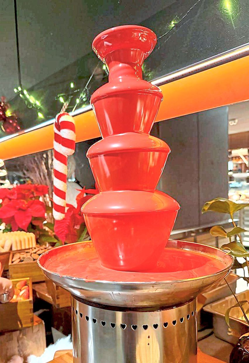 The chocolate fountain adds a playful touch to the dessert station with white chocolate tinted pink for the season.