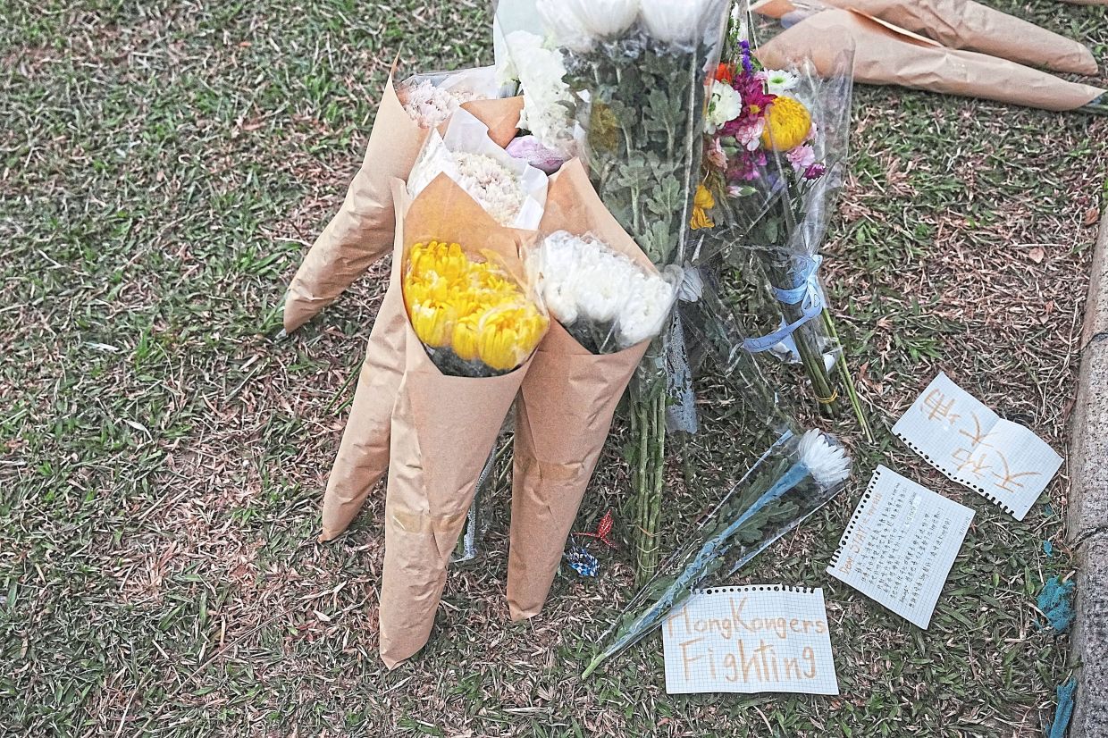 In living memory: (Above and below) Flower tributes at a makeshift memorial at the Wang Fuk Court housing complex. — Reuters 