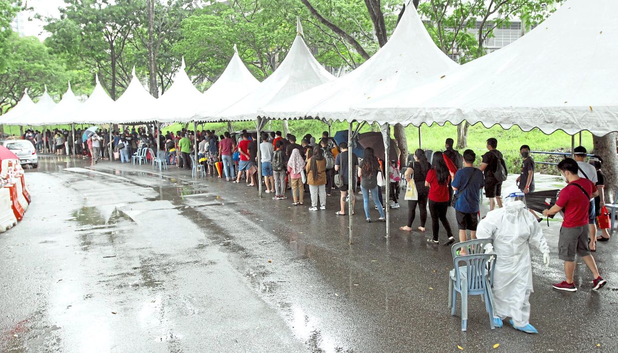 Covid-19 patients queuing up to enter the Covid-19 Assessment Centre at Malawati Stadium in Shah Alam, Selangor, in May 2021. The public healthcare system was almost completely overwhelmed during certain periods of the pandemic.