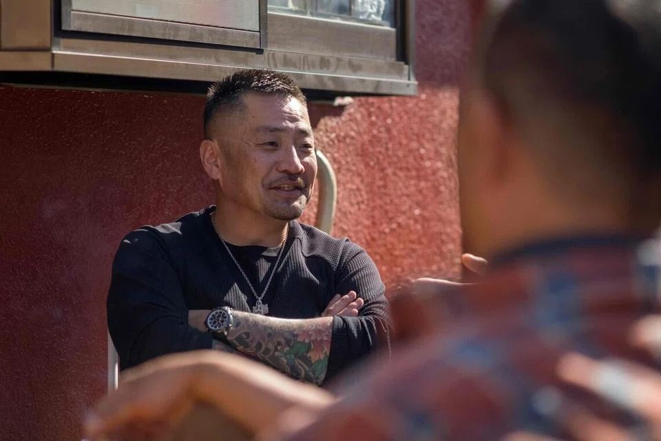 Former gangster Yoshiro Nishino (left) chatting with residents of his group home for ex-offenders in Chiba Prefecture. -- PHOTO: AFP