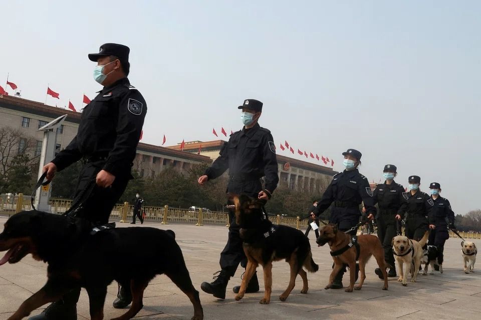 FILE PHOTO: Police officers patrol with dogs on Tiananmen Square before the second plenary session of the National People's Congress (NPC) at the Great Hall of the People in Beijing, China March 8, 2021. - Photo: Reuters file