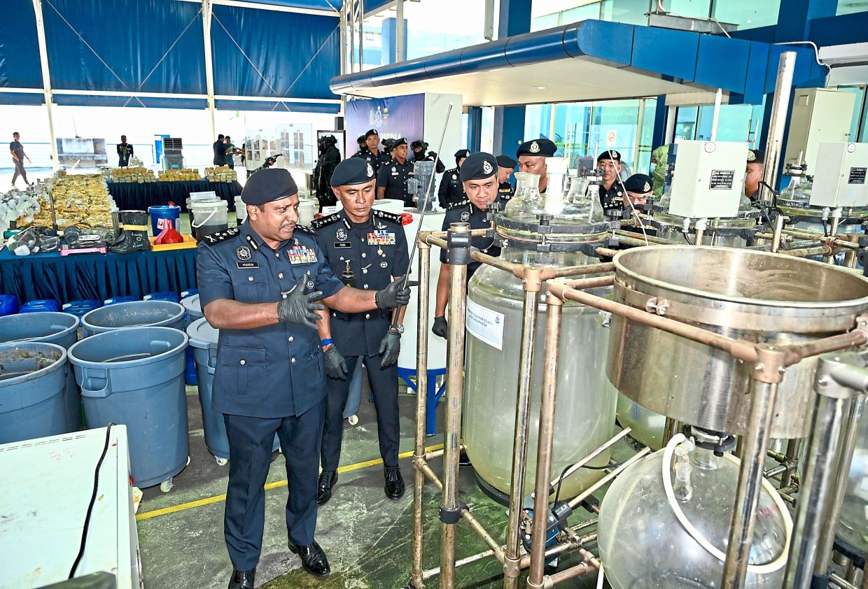 Comm Hussein (right) showing the massive vats used to manufacture the drugs. With him are Kuala Lumpur police chief Comm Datuk Fadil Marsus and other senior police officers. — RAJA FAISAL HISHAN/The Star