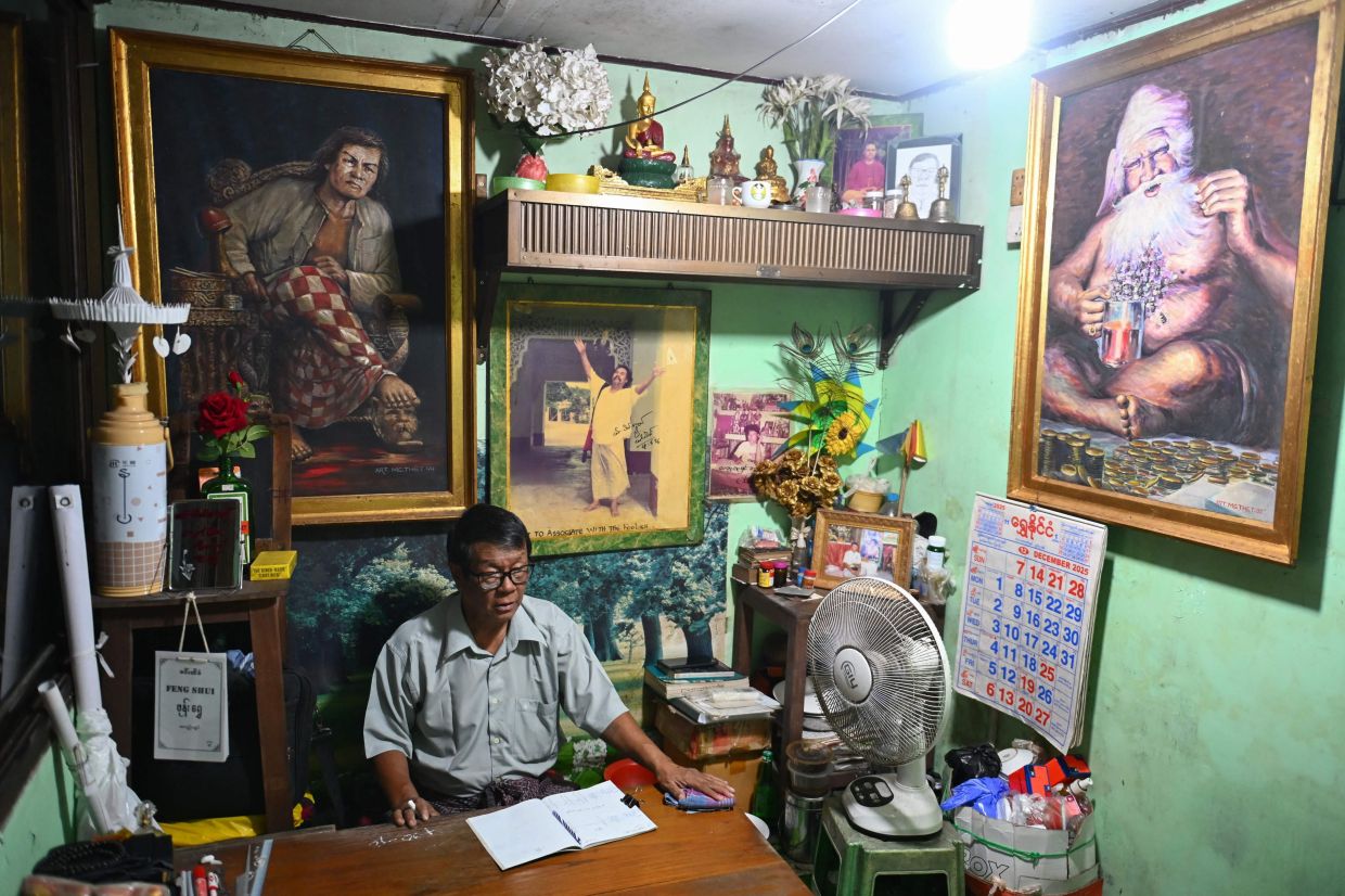 Astrologer Min Thein Kyaw at his fortune-telling studio in Yangon. - AFP