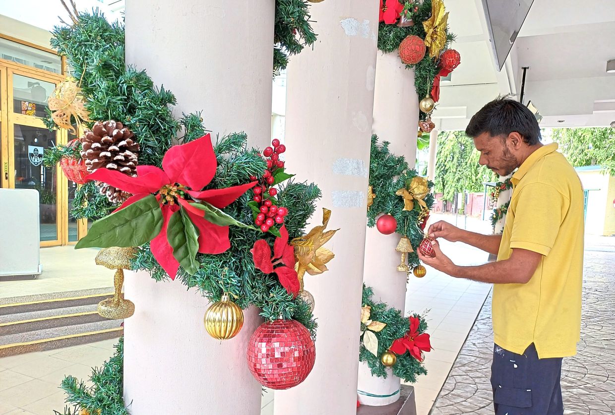 Workers set up Christmas decorations at the main entrance of the Saint Francis Xavier Church in Petaling Jaya.