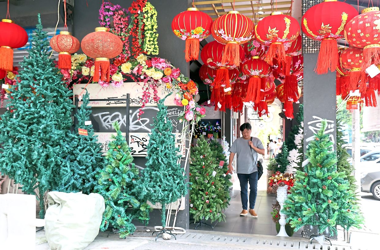 A shop displaying both Christmas trees and bright red lanterns in Petaling Street, Kuala Lumpur.
