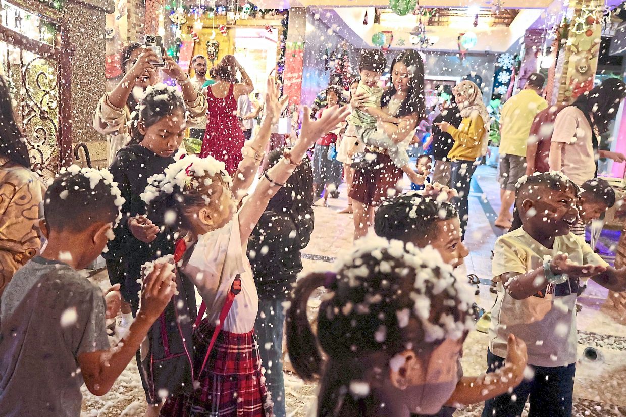 BubblyChristmas:A groupof childrenenjoying thefalling ‘snow’ atthe house. —ZHaFarannaSIb/The Star