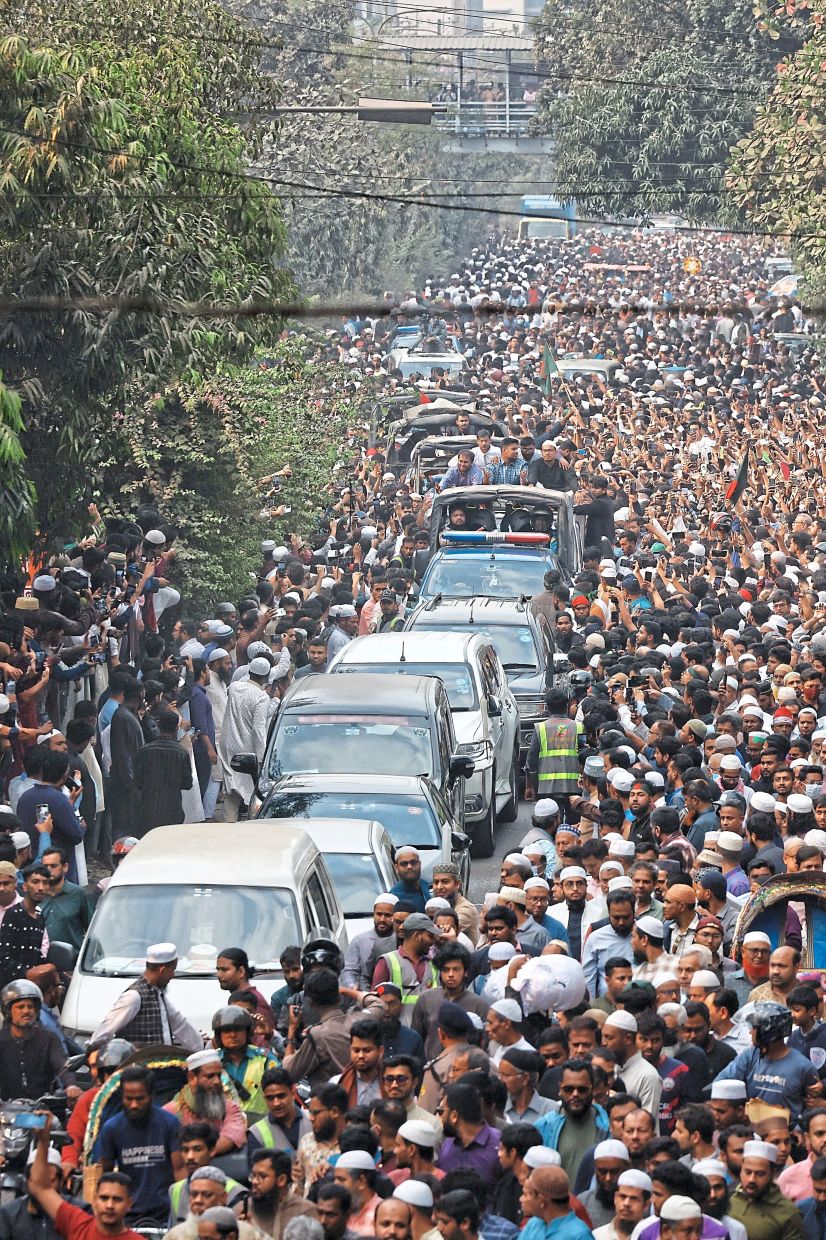 Sombre farewell: A convoy carrying the body of Sharif moving along the crowd after the funeral prayer in Dhaka. — Reuters