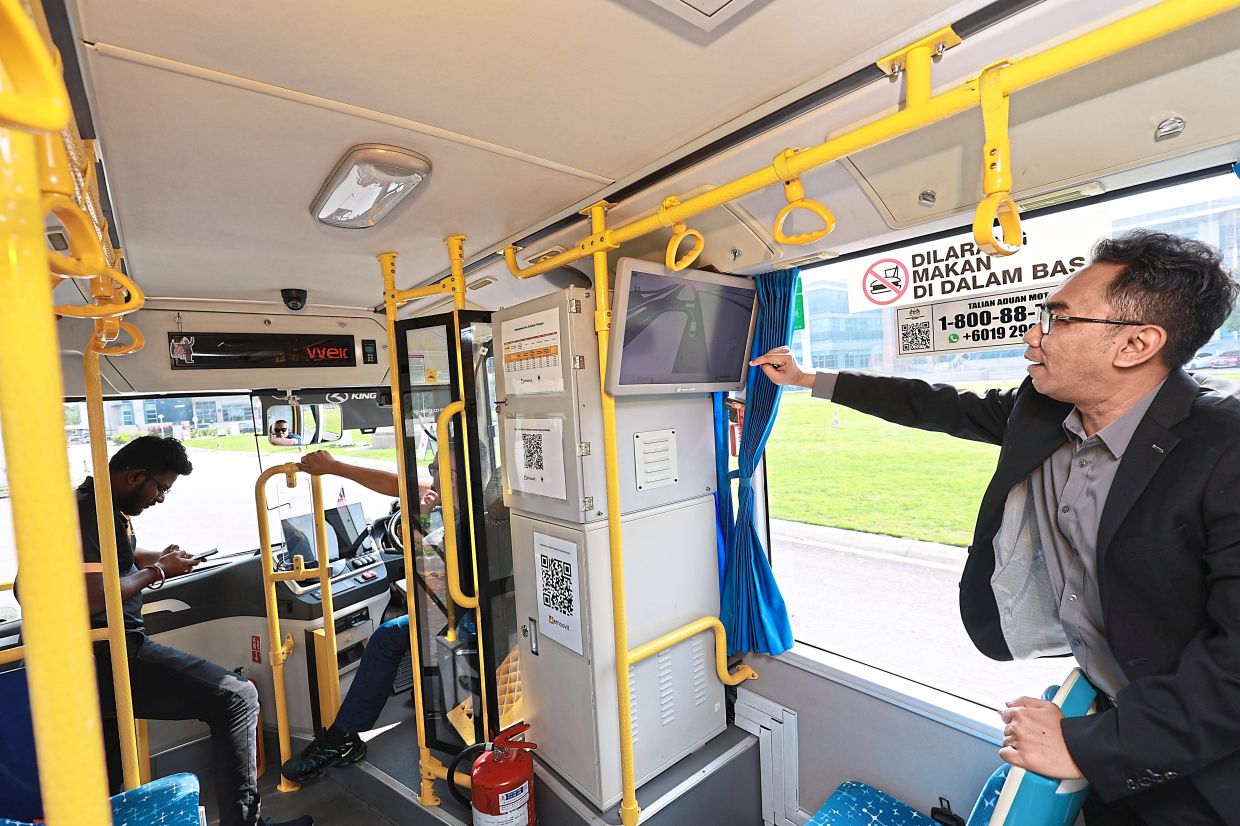 Hairi pointing out a screen that shows what the sensors on the bus are seeing during a demo with StarLifestyle. — KAMARUL ARIFFIN/TheStar
