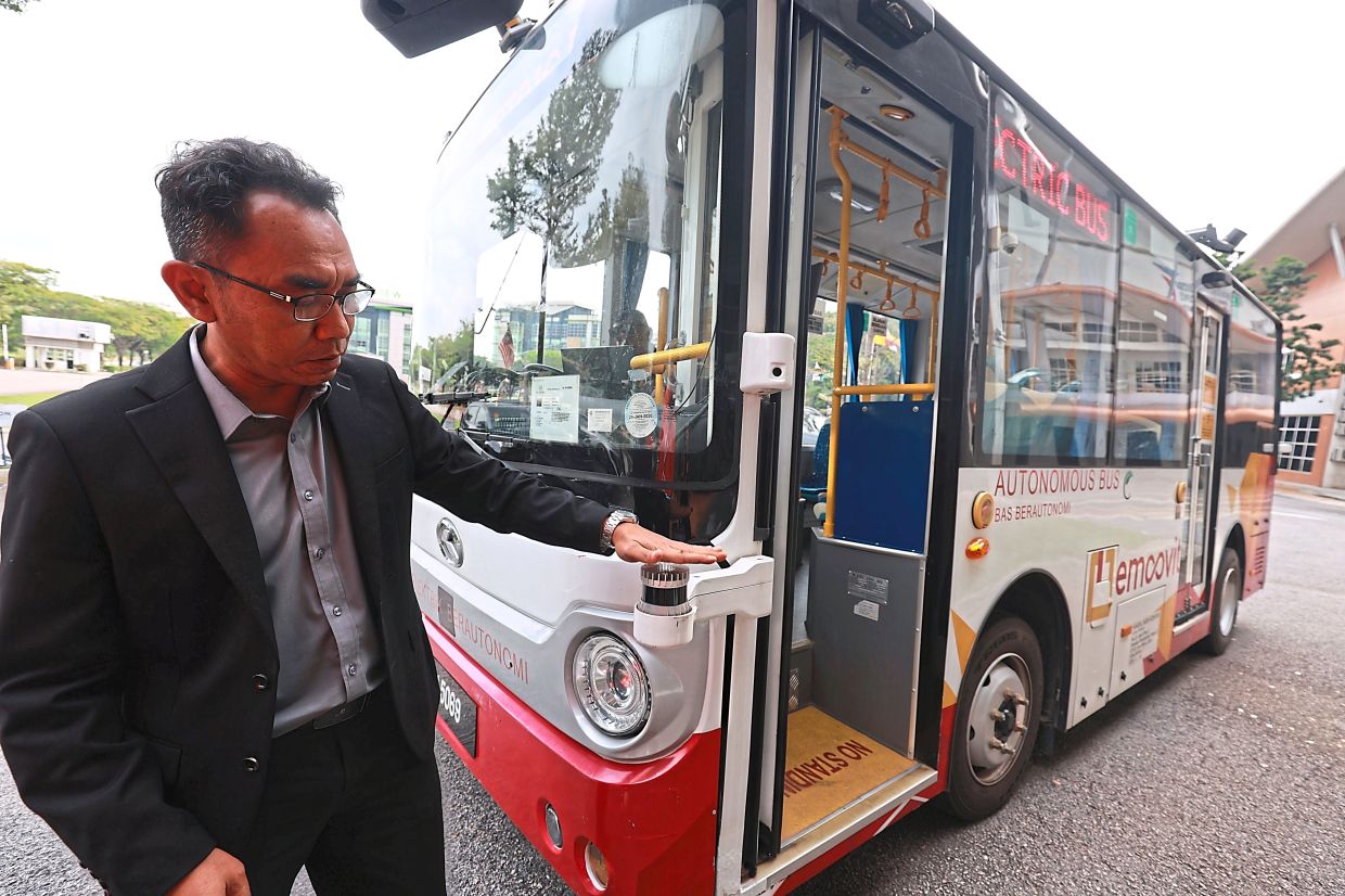 Hairi pointing at one of the Lidar sensors on the bus. — KAMARUL ARIFFIN/TheStar