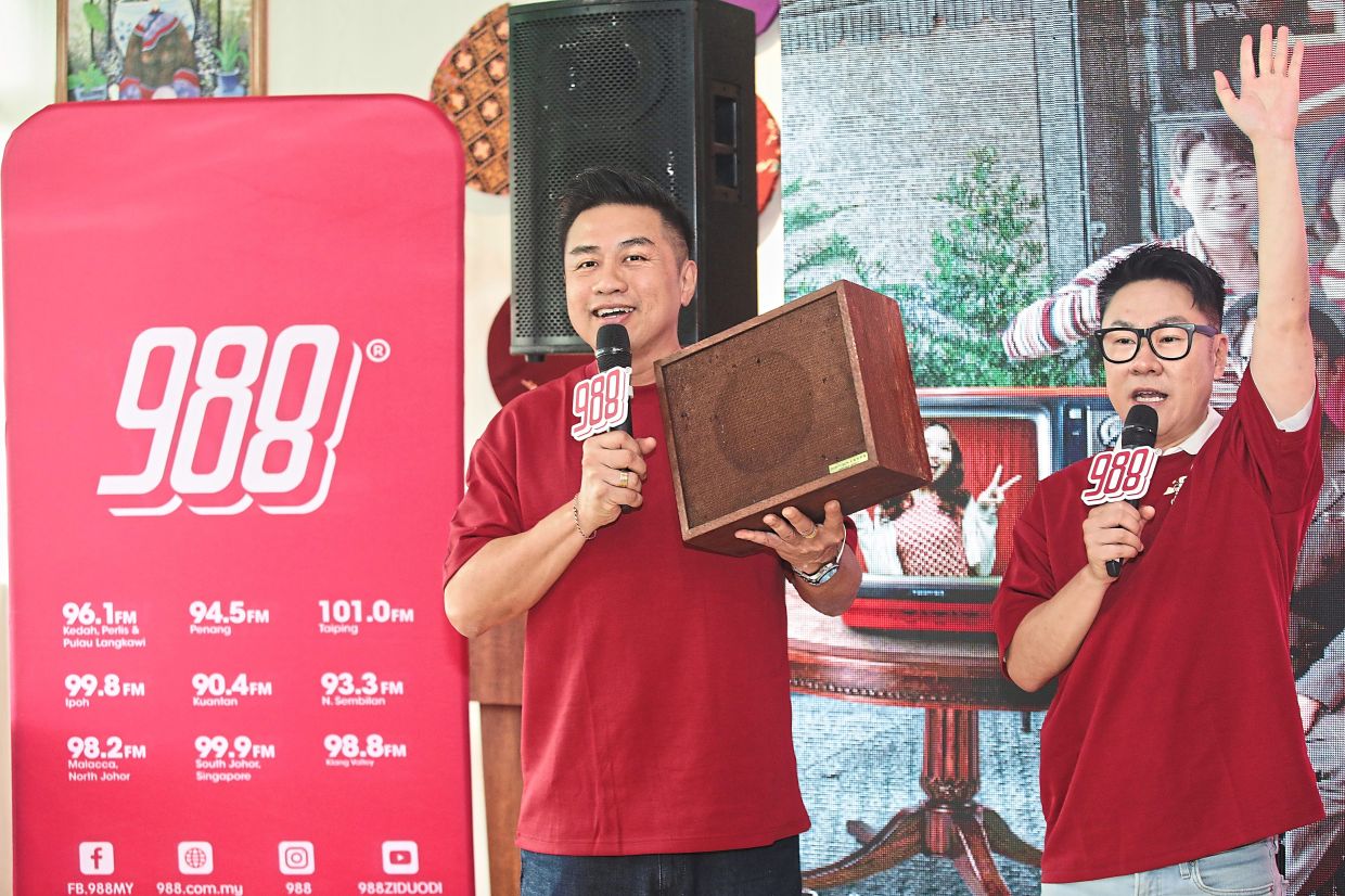 988 DJ Chan Fong carrying the Rediffusion box featured in 988’s CNY MV on its social media platforms. Beside him is DJ Jeff Chin.