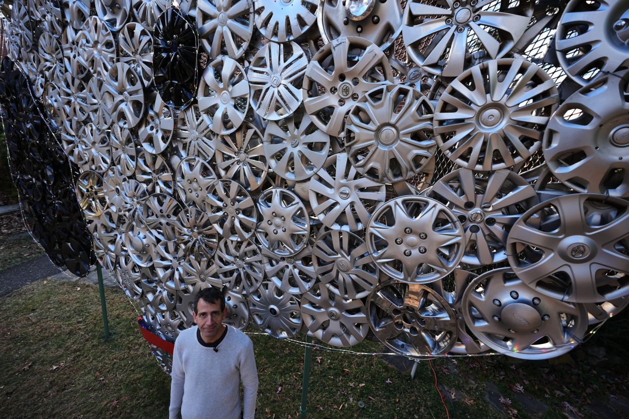 Recycling cyclist: US cyclist collects lost hubcaps and turns them into art