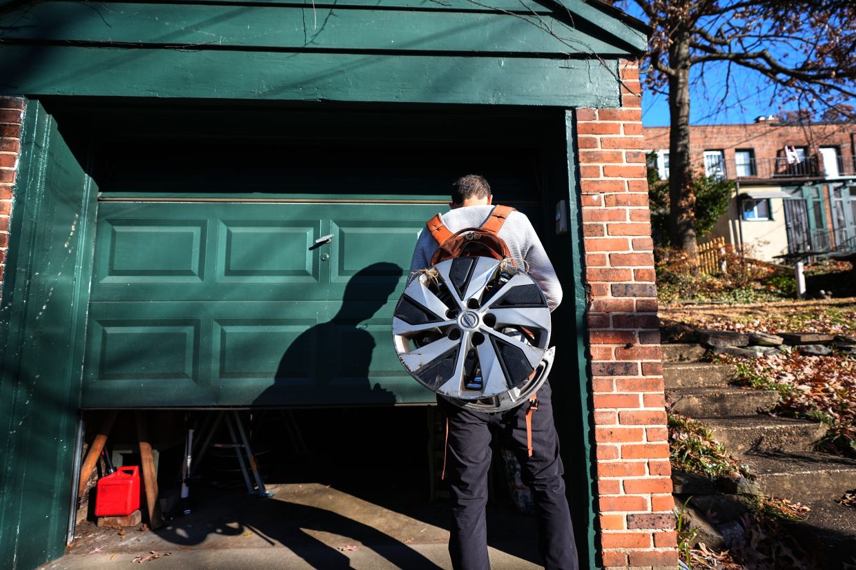 Cyclist Barnaby Wickham enters his garage where he stores his collection of hubcaps, Thursday, Dec. 11, 2025, at his home in Baltimore. (AP Photo/Stephanie Scarbrough)