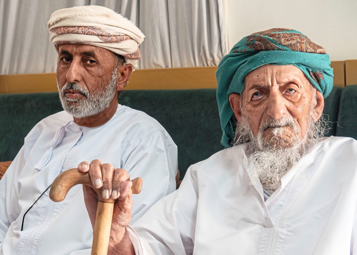 Al-Rashdi (left), seated with his father, proclaims that he is still a Bedouin, even though he now lives in a modern home with air conditioning.
